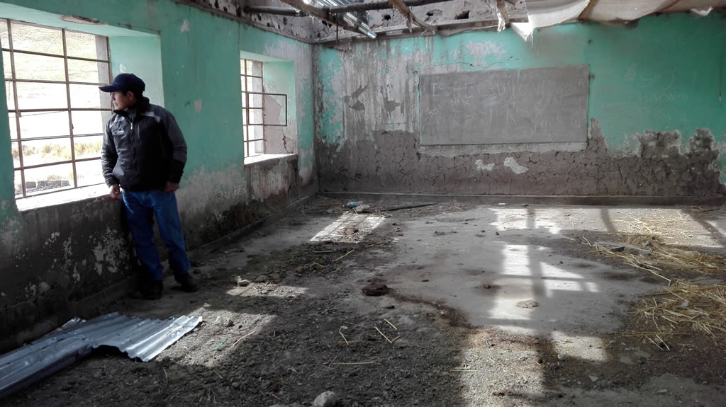 The president of the Huisa community, Juan Magaño, appears among the rubble of what was the area’s emblematic school.  Today it is abandoned due to the pollution. Photo: Milagros Salazar.